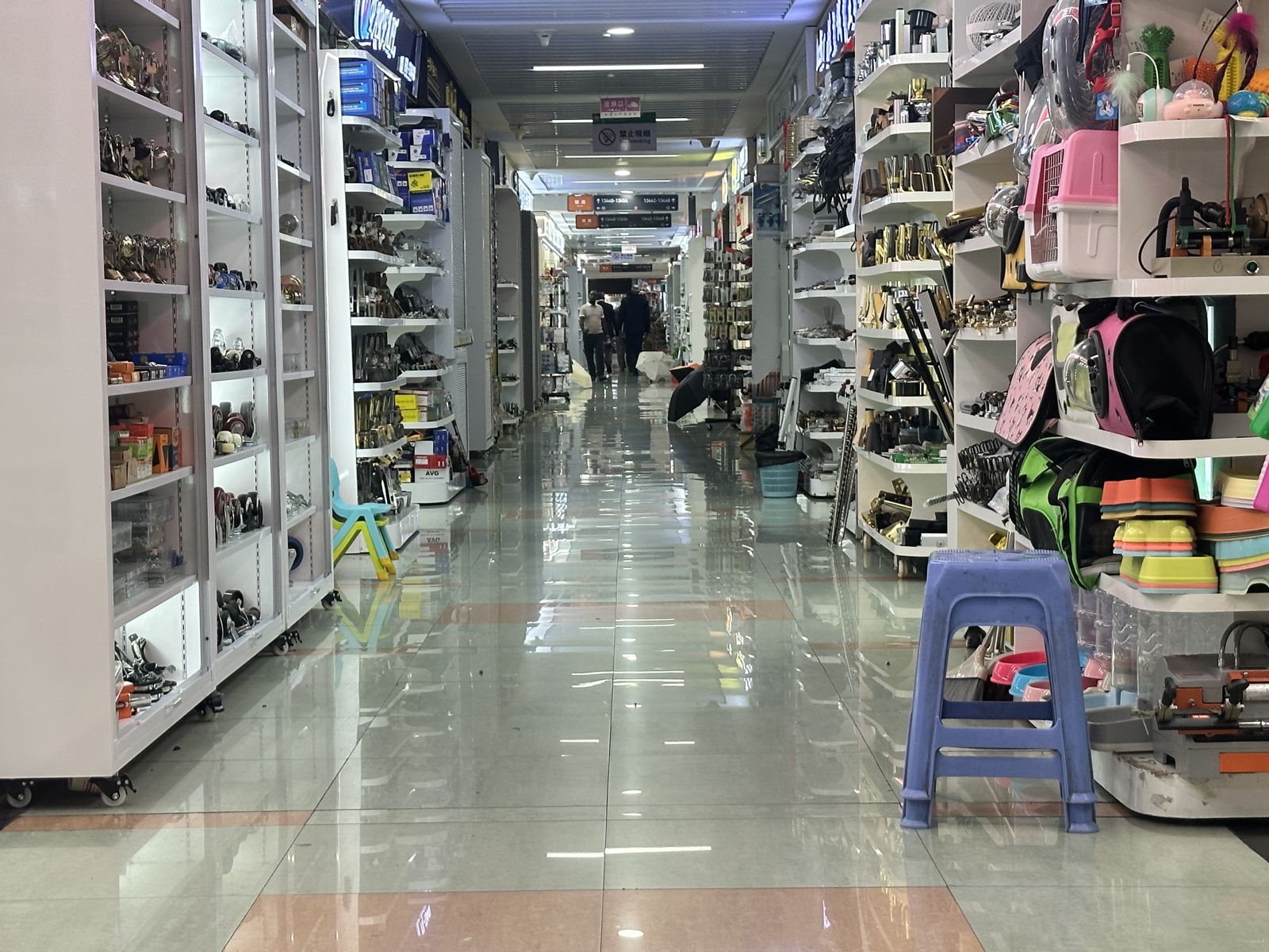 Suitcases and bags displayed along a wholesale market aisle