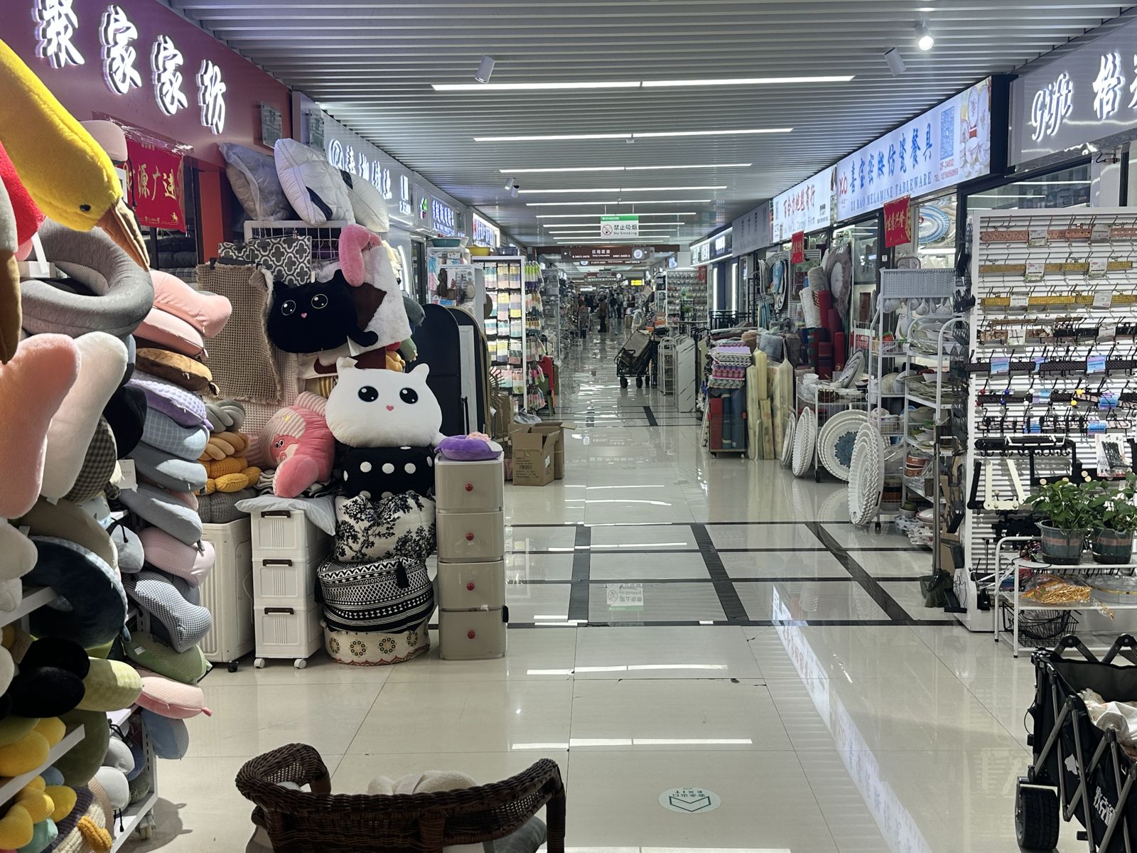 Pink-toned household goods stall along a wholesale market aisle